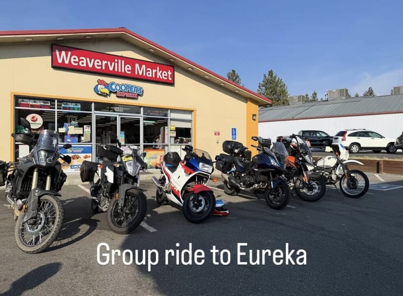 Five motorcycles parked in a row in front of Weaverville Market in Northern California during a group ride to Eureka